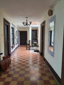 a hallway with a checkered floor in a house at Hotel Acatenango Inn in Antigua Guatemala