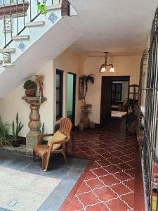 a living room with a staircase and a chair at Hotel Acatenango Inn in Antigua Guatemala
