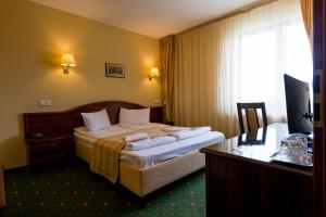 una camera d'albergo con letto e scrivania di Coroana Brasovului a Braşov