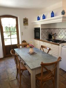 a kitchen with a table with chairs and blue vases on it at romantique villa provencale in Bargemon