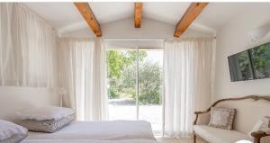 a bedroom with a bed and a large window at romantique villa provencale in Bargemon