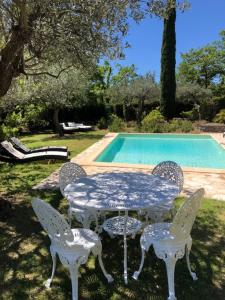 a table and chairs next to a swimming pool at romantique villa provencale in Bargemon +18 photos