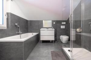 a bathroom with a tub and a toilet and a sink at Urlaubsplatzl Appartements in Oetz