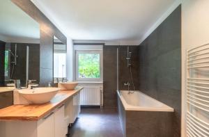 a bathroom with two sinks and a tub at Urlaubsplatzl Appartements in Oetz