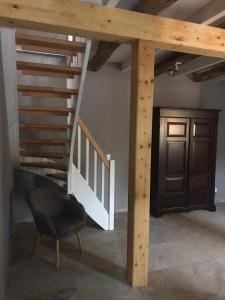 a staircase in a room with a chair and a stair case at Fachwerk-Maisonette-Wohnung -zur Tenne- in Rieste