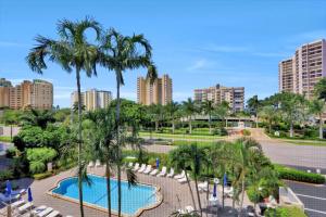 a view from the balcony of a resort with palm trees at Breezy condo with deluxe pool and private beach access in Marco Island