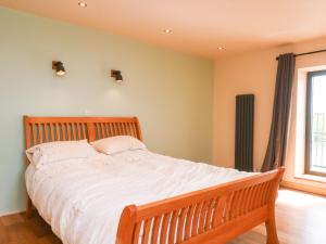 ein Schlafzimmer mit einem Bett mit weißen Laken und einem Fenster in der Unterkunft Bowland Barn in Lancaster