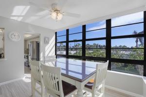 a dining room with a table and chairs and a window at Ideal beachfront condo with pool and two balconies in Marco Island