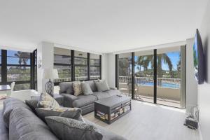 a living room with a couch and a tv in it at Ideal beachfront condo with pool and two balconies in Marco Island