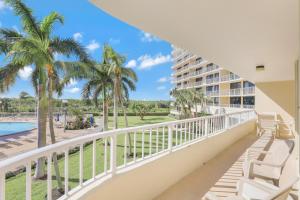 a balcony with palm trees and a resort at Ideal beachfront condo with pool and two balconies in Marco Island