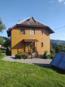 ein Holzhaus mit einem Dach auf einem Hof in der Unterkunft Гірська вершина in Slawske