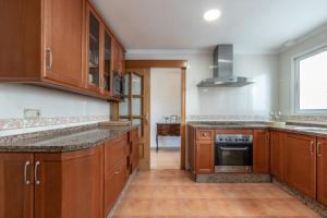 eine Küche mit Holzschränken und Granitarbeitsflächen in der Unterkunft Apartamento de 3 habitaciones en el barrio de las Artes, Soho in Málaga