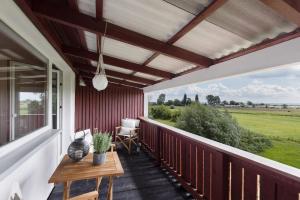 a porch with a wooden table and a view of a field at Strandkoje Wohnung 4 in Rettin