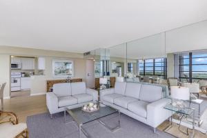 a living room with two white couches and a table at South Seas Tower 3-411 in Marco Island