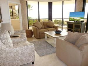 a living room with a couch and chairs and a tv at Sandcastle I-101 in Marco Island
