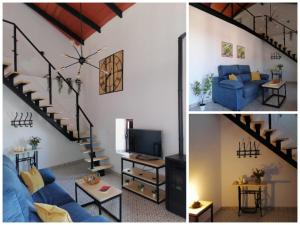 a living room with a blue couch and a staircase at La casita de Fuente Obejuna in Fuente Obejuna