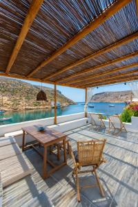 un patio con mesa y sillas y vistas al agua en Psarona Hospitality, en Cherronisos