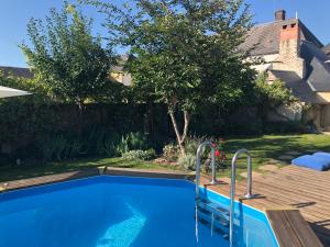 a swimming pool in the backyard of a house at Le Chaton Rouge in Saint-Pierre-du-Lorouër