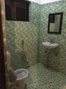 łazienka z toaletą i umywalką w obiekcie Hotel Gainda Island Camp w mieście Sauraha