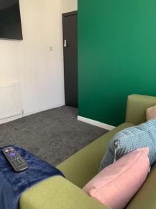 a living room with a couch and a remote control at LFC Staycation in Liverpool