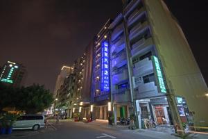 台南的住宿－皇賓大飯店，一座建筑物,晚上在建筑物的一侧有蓝色标志