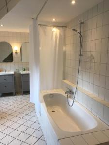 a bathroom with a bath tub with a shower at Landhaus von Frieling - Neuenkirchen in Neuenkirchen