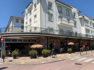 a building with umbrellas in front of a restaurant at Hotel Cantabrico in Liérganes