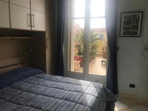 a bedroom with a bed and a large window at Appartement terrasse dans palace Belle Epoque in Menton