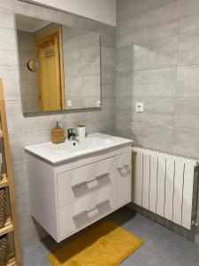 ein Badezimmer mit einem weißen Waschbecken und einem Spiegel in der Unterkunft Puro encanto en el corazón de Santo Domingo in Santo Domingo de la Calzada