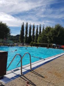 a large swimming pool with people in the water at La Belle Auvergne in Condat