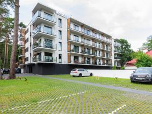 biały samochód zaparkowany przed budynkiem w obiekcie VacationClub – Sosnowa 4 Apartament 36 w mieście Mielno