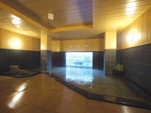 Habitación grande con piscina de agua en un edificio en Hotel Route-Inn Tome, en Tome