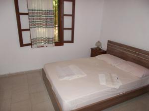 a bedroom with a bed with white sheets and a window at Villa Mina in Potistika