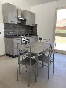 een keuken met een tafel en stoelen en een fornuis bij Casa Aranci@verde in Marsala