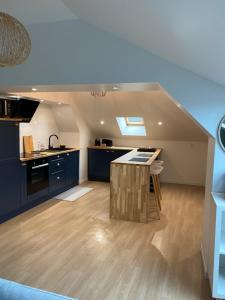 a kitchen with a island in the middle of a room at Un petit coin sous les toits in Épernay
