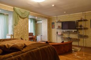 a bedroom with a bed and a flat screen tv at Mercury Hotel Complex in Nakhodka