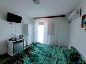 a bedroom with a bed and a desk in it at Vila Atipic in Costinesti