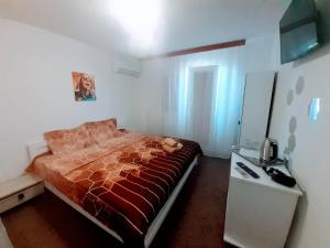 a bedroom with a bed with a red comforter at Vila Atipic in Costinesti