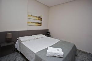 een slaapkamer met een bed met twee handdoeken erop bij LK Lourdes 8 in Belo Horizonte