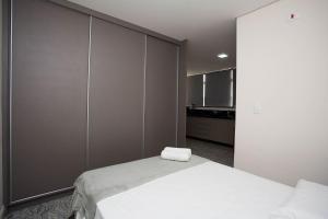 1 dormitorio con cama blanca y pared grande en LK Lourdes 8, en Belo Horizonte 15 fotos más