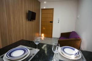 een eettafel met borden en wijnglazen erop bij LK Lourdes 8 in Belo Horizonte