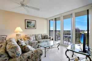 a living room with a couch and a glass table at Sunny beachfront condo with pool and SW-facing balcony in Marco Island