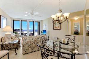 a dining room and living room with a glass table at Sunny beachfront condo with pool and SW-facing balcony in Marco Island