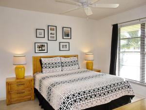 a bedroom with a bed and two lamps and a window at Inviting condo with pool just a steps from the beach in Marco Island +17 photos