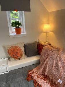 a bedroom with a couch with a lamp and a window at JustB Edinburgh in Edinburgh