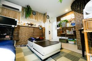 ein Wohnzimmer mit einem Sofa und einem TV in der Unterkunft Plage Yuigahama in Kamakura