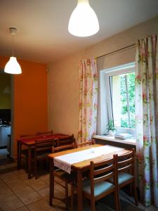 a dining room with a table and chairs and a window at Pod Gadającym Kotem in Długopole-Zdrój