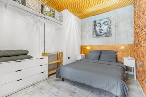een slaapkamer met een bed en een bakstenen muur bij Tender loft in Odessa