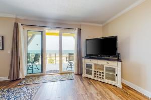 ein Wohnzimmer mit einem Flachbild-TV und einem Balkon in der Unterkunft Summerhouse 402 in Mexico Beach