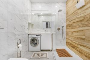 een witte badkamer met een wasmachine in een douche bij Tender loft in Odessa